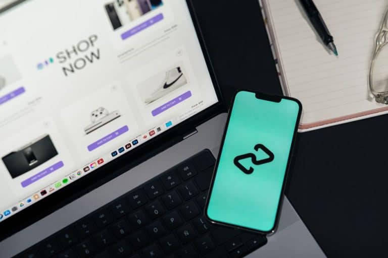 Dispositivo móvil y laptop con página de tienda online en diseño moderno.