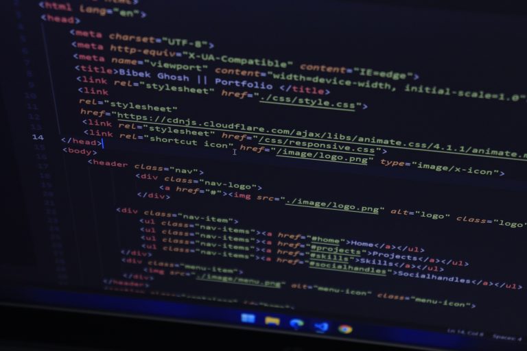Código HTML en pantalla de monitor con etiquetas semánticas y metadatos para optimización SEO e inteligencia artificial